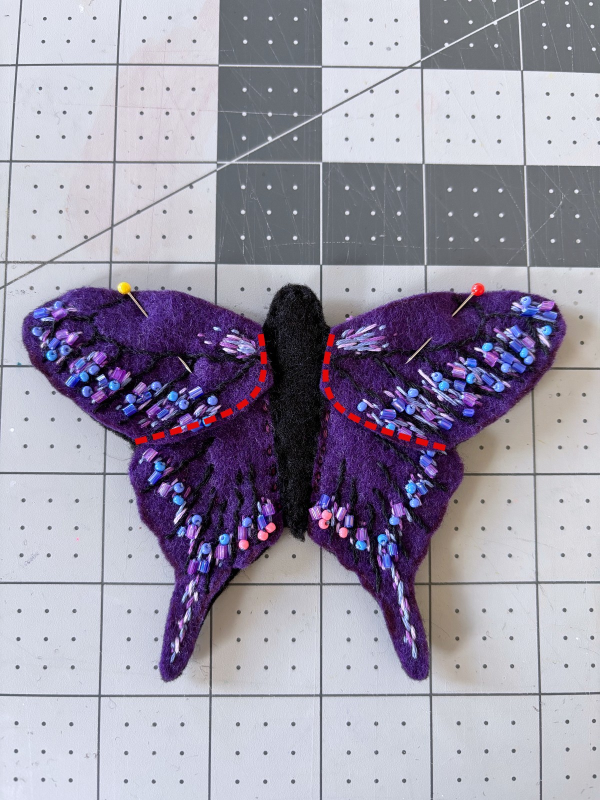 Top butterfly wings placed on base with red lines indicating where to sew.