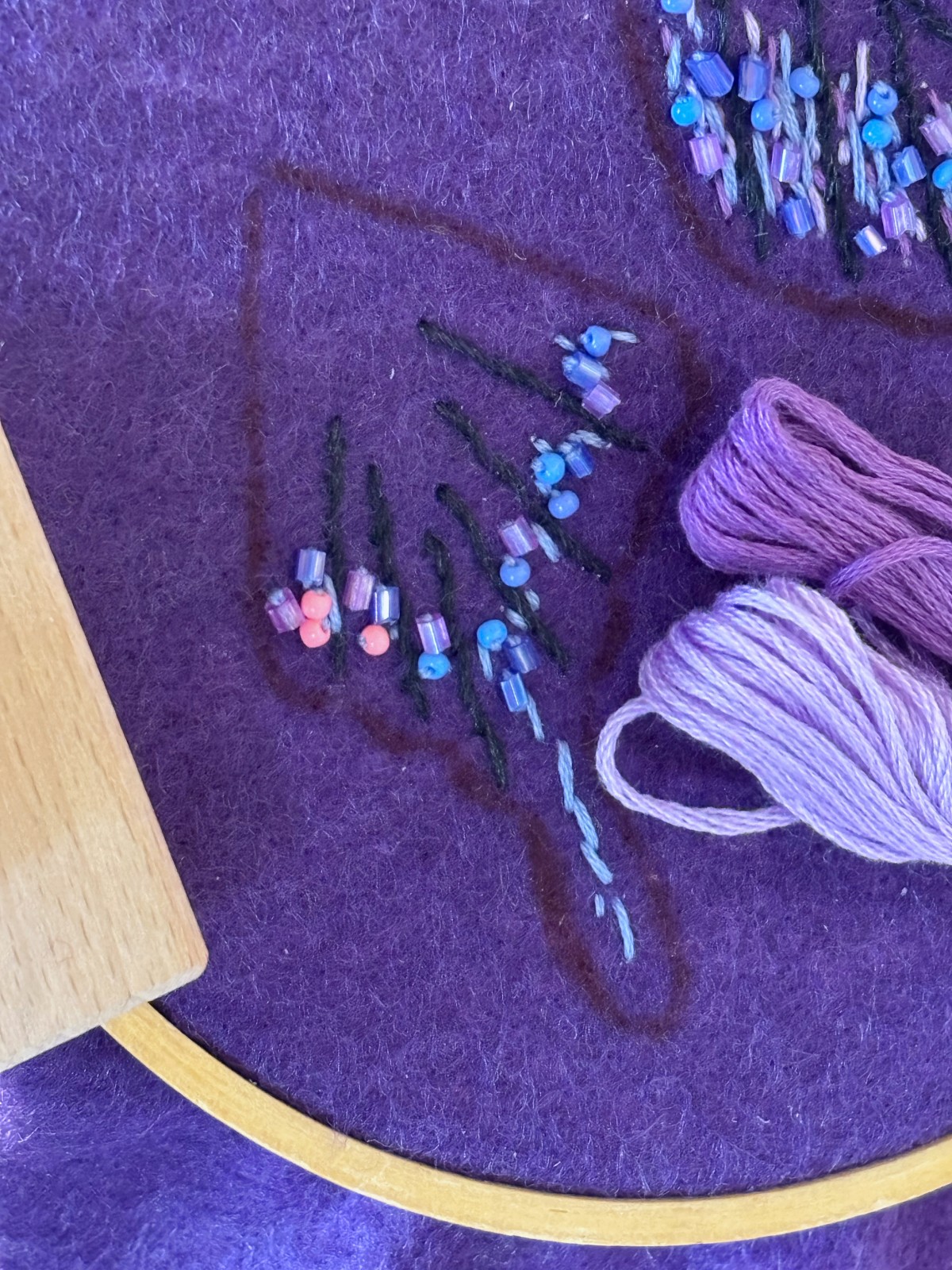 Bottom wing with purple embroidered and beaded details.
