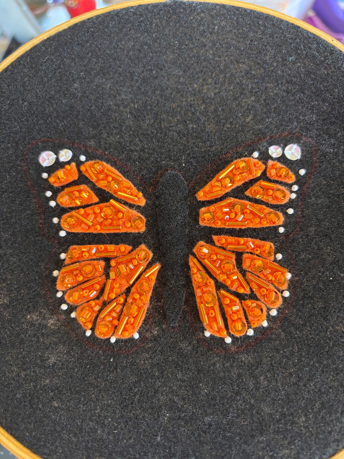 Finished sequin and bead details in each orange section of the wings.