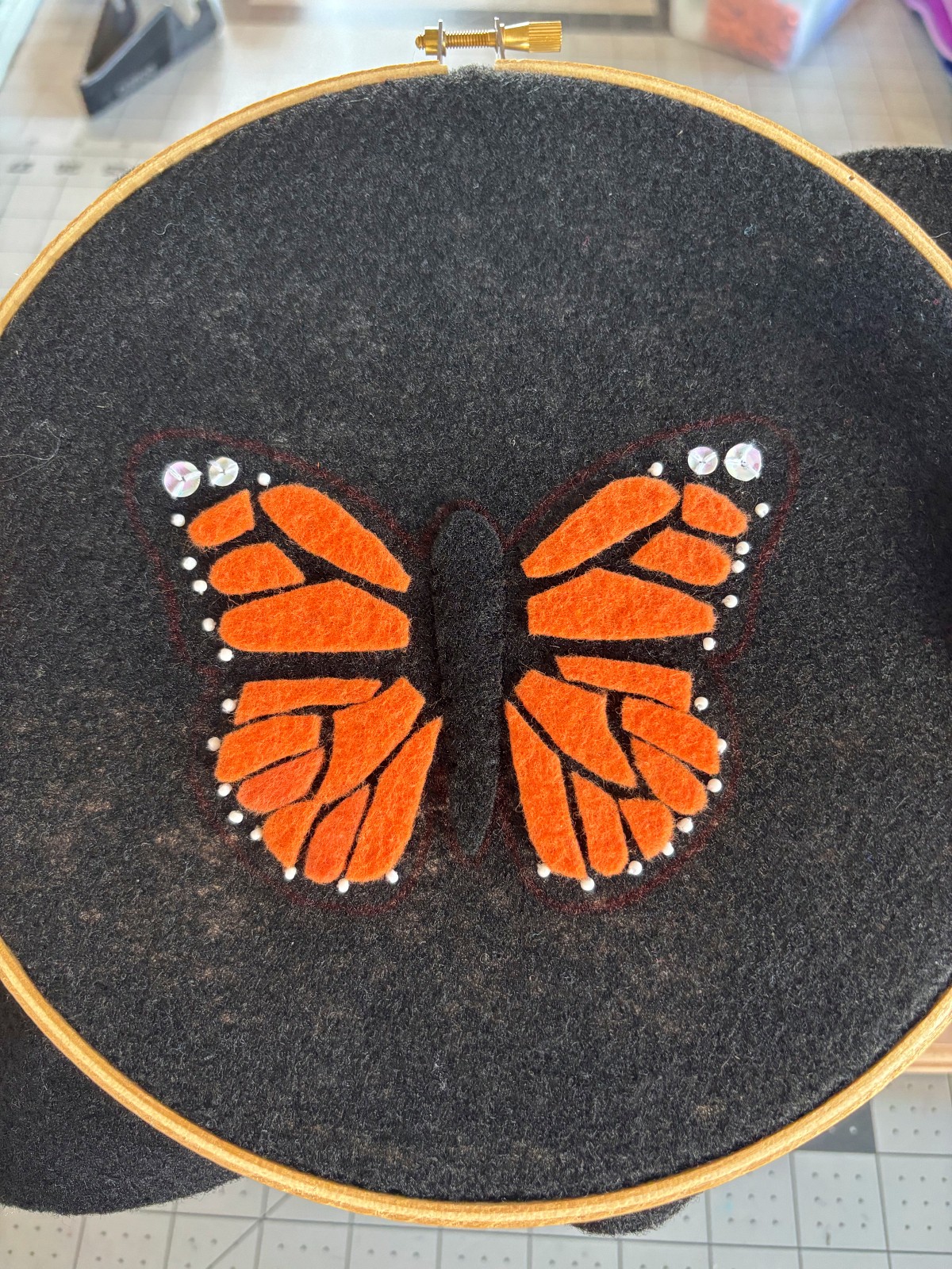 Finished white sequin and bead details sewn on the edge of both wings.