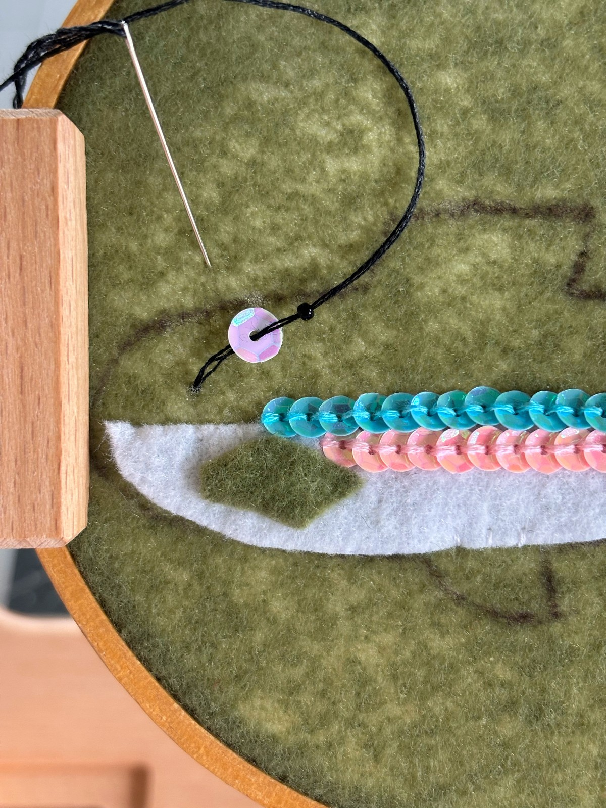 Step one of sewing on the trout eye.