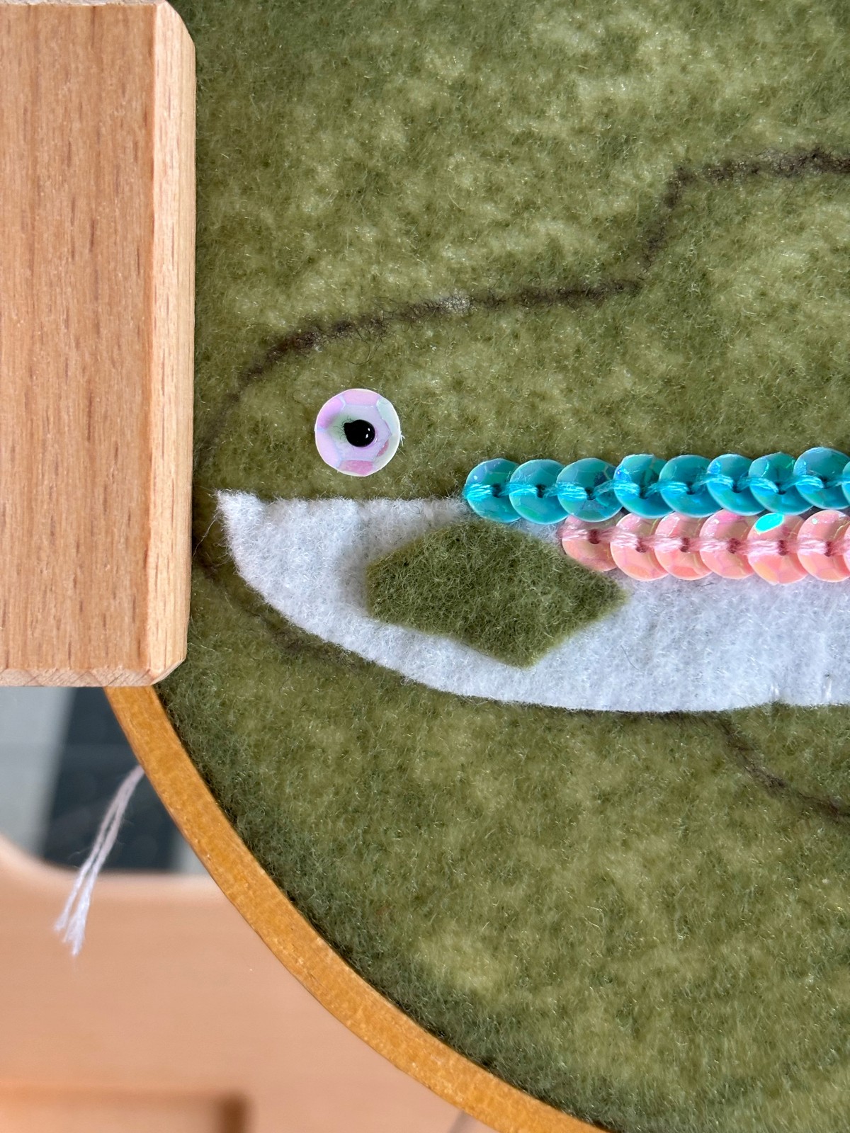 Step 2 of sewing on the trout eye.
