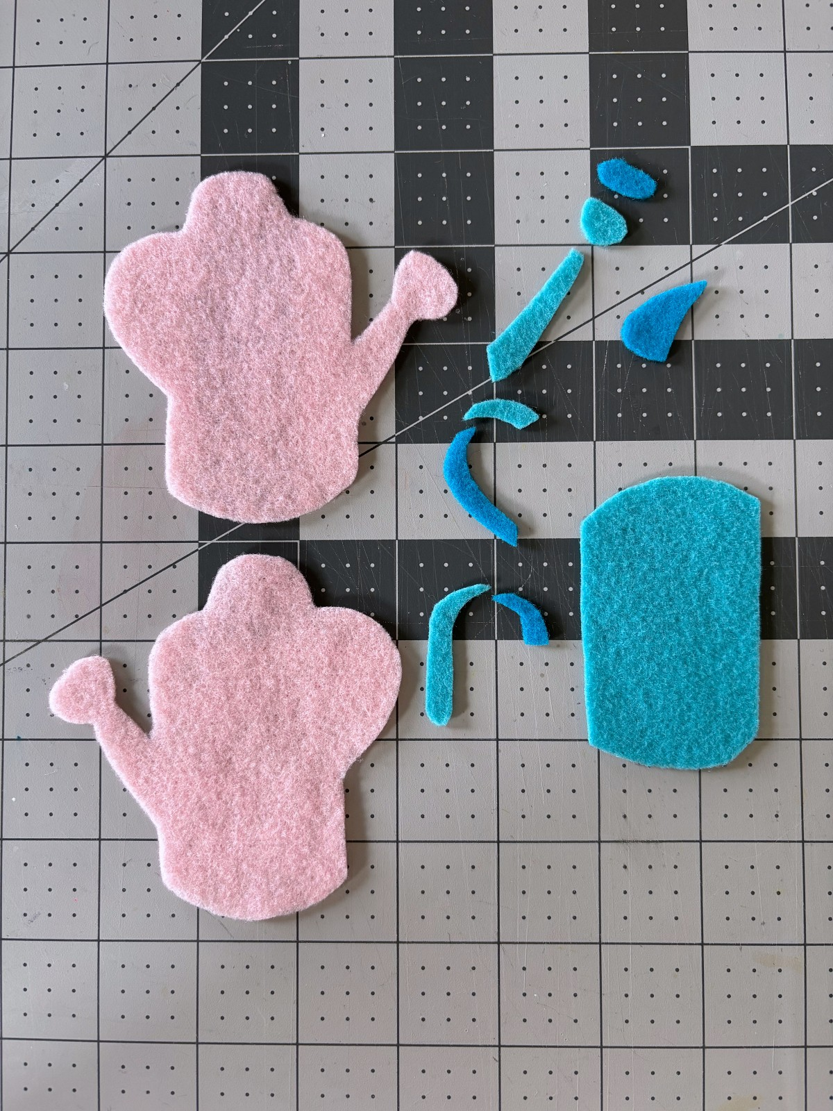 All pattern pieces cut out of felt on a table.