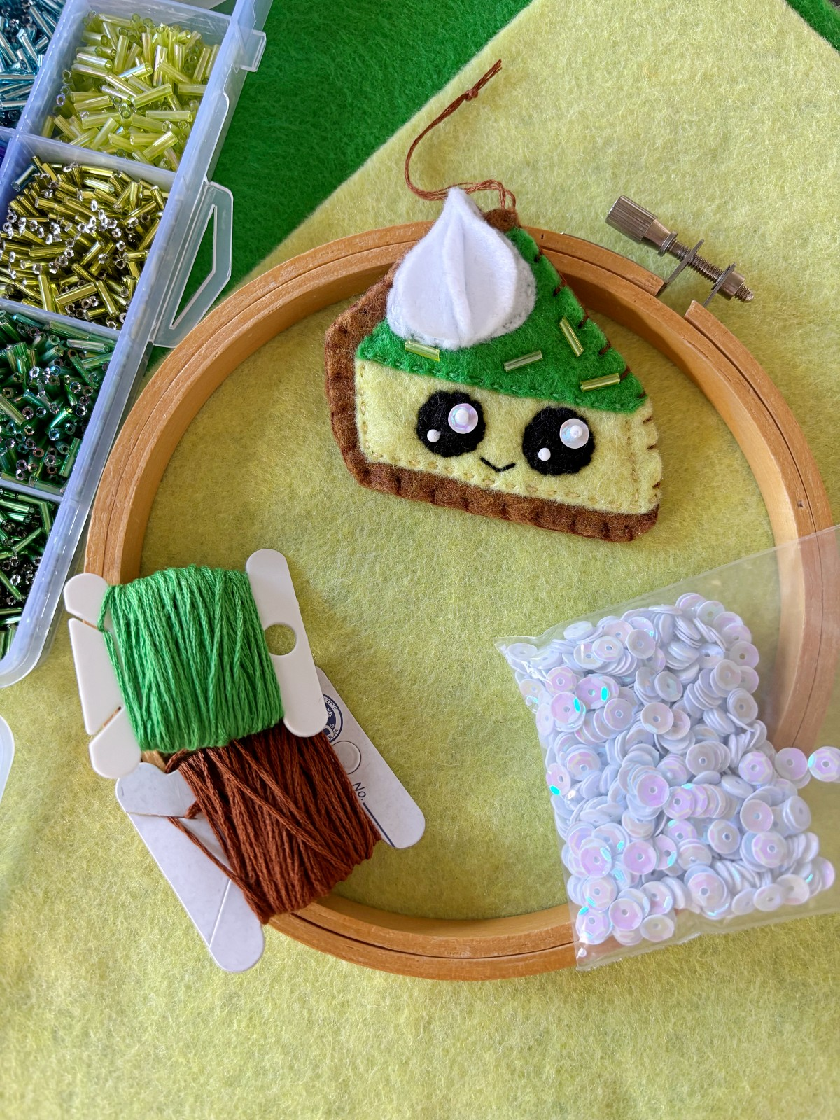 Finished Lime Pie Ornament with crafting materials around it on a table.