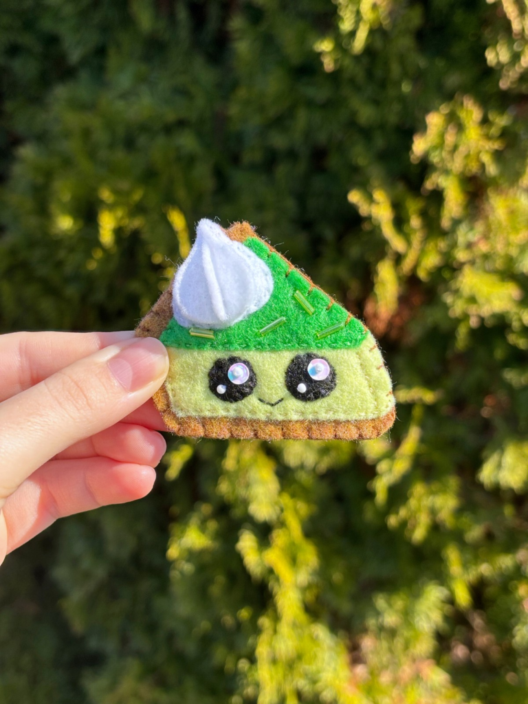 Hand holding felt lime pie ornament.