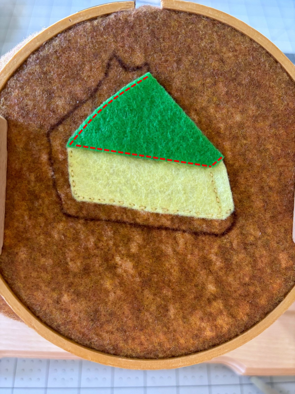 Top pie layer placed on brown base with sewing guide lines.