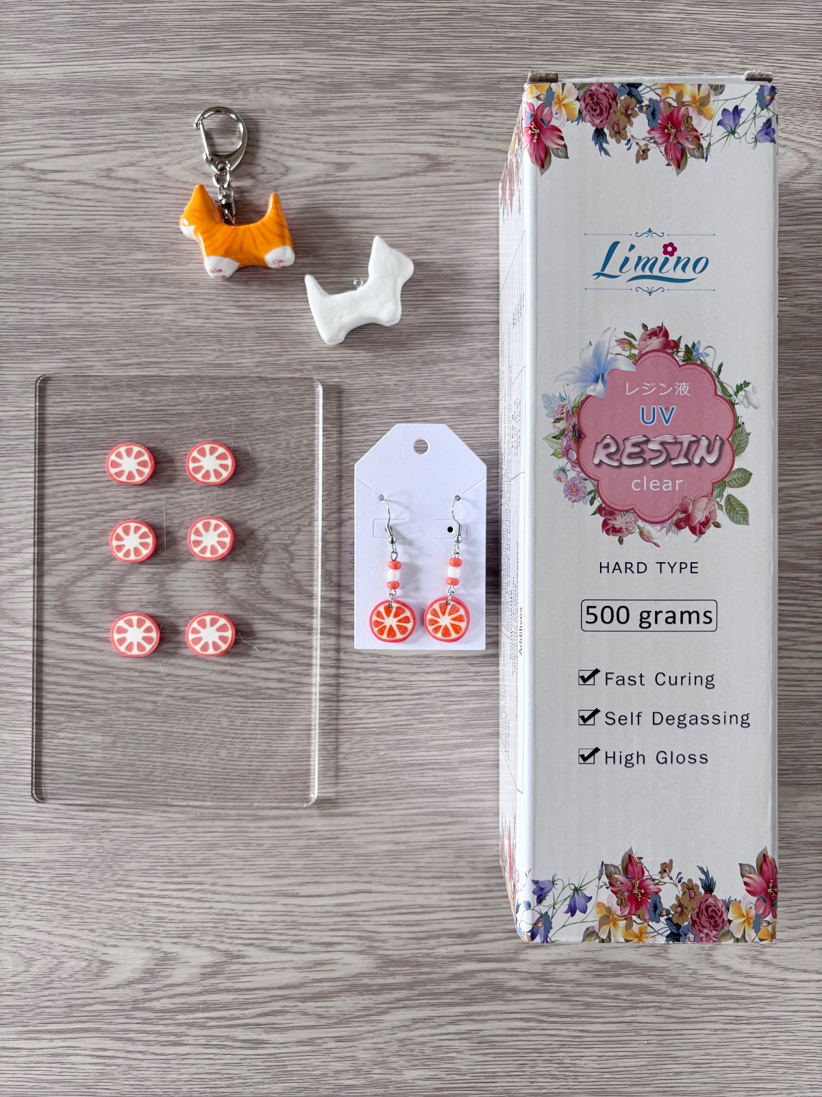 Charms, earrings, and UV resin on a table.