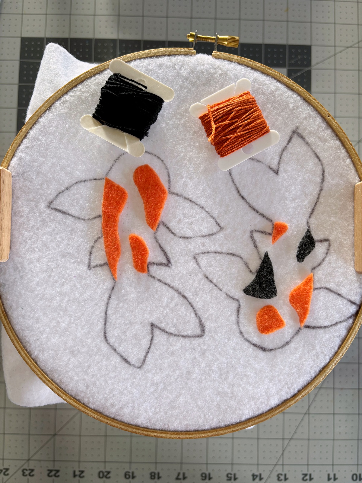 Pattern options arranged on the base with black and orange embroidery thread.