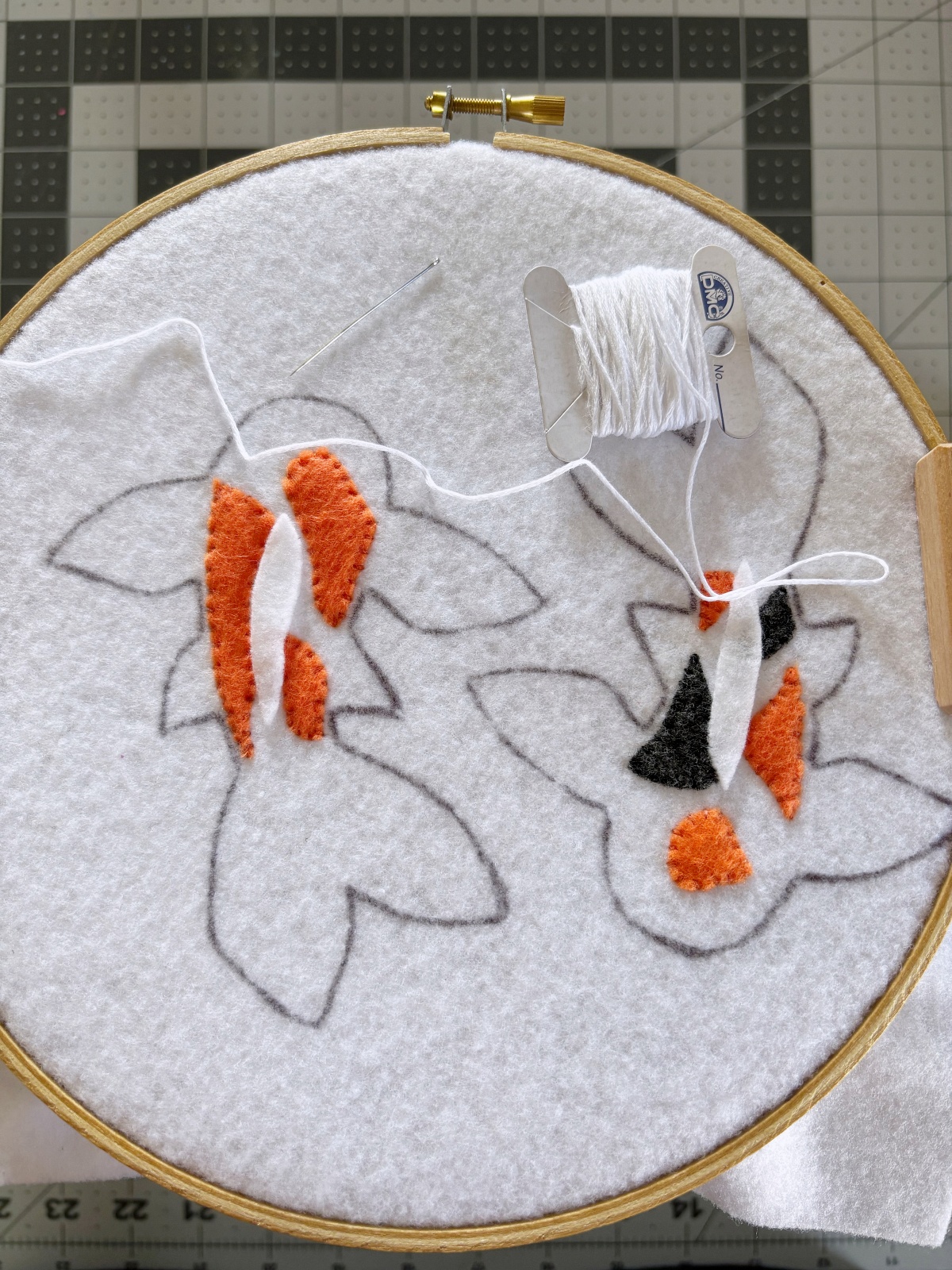 Top fin placed on the base and white embroidery thread.