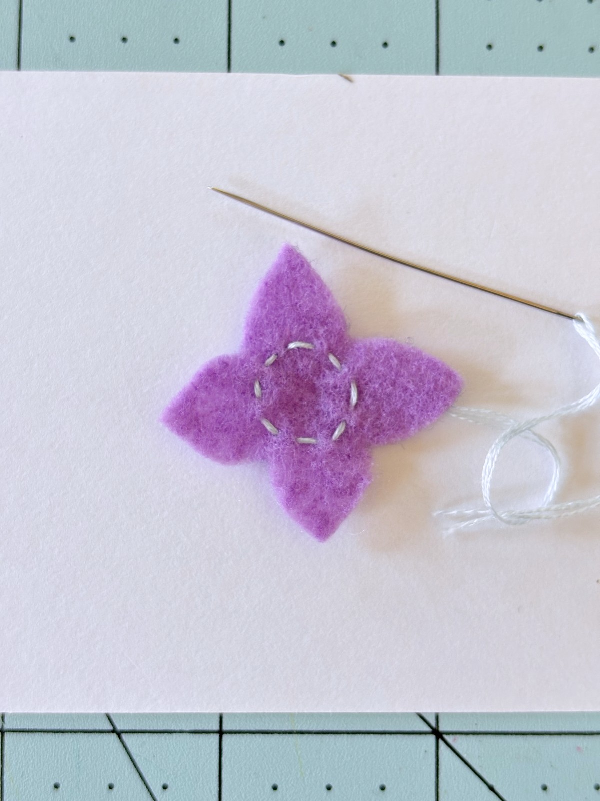 Running stitch in the middle of felt flower.