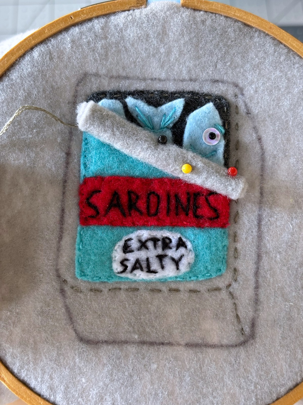 Rolled sardine can lid piece pinned in place on the ornament.
