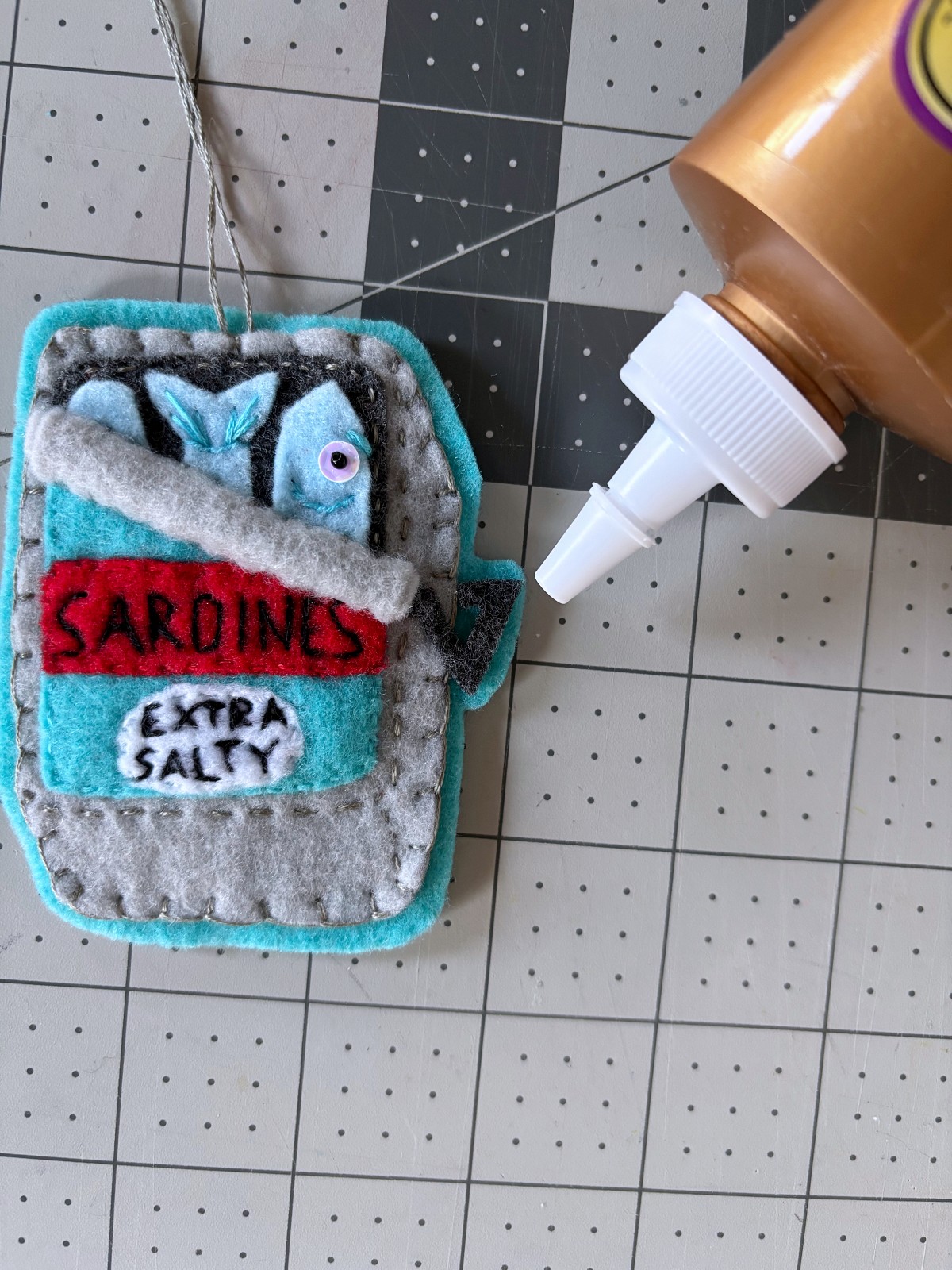 Gluing on the sardine can ornament handle piece with tacky glue.