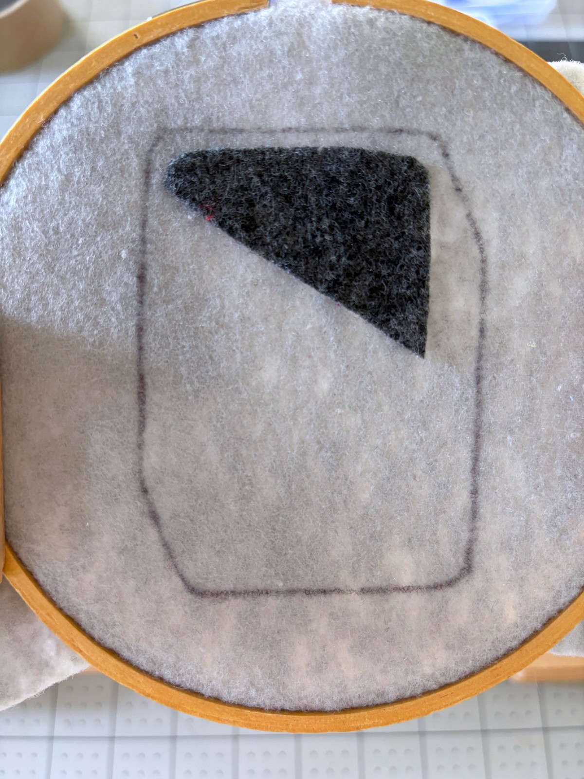 Dark gray pattern piece placed on light gray base.