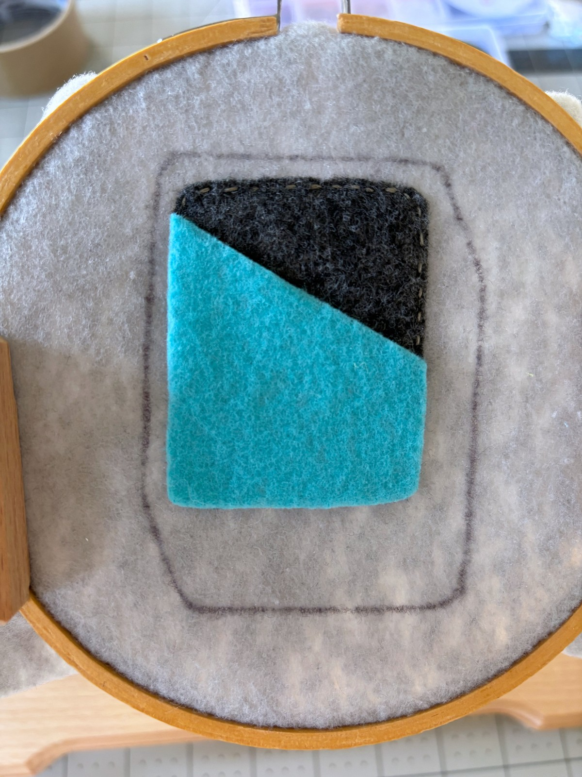 Teal felt piece placed on light gray can base.
