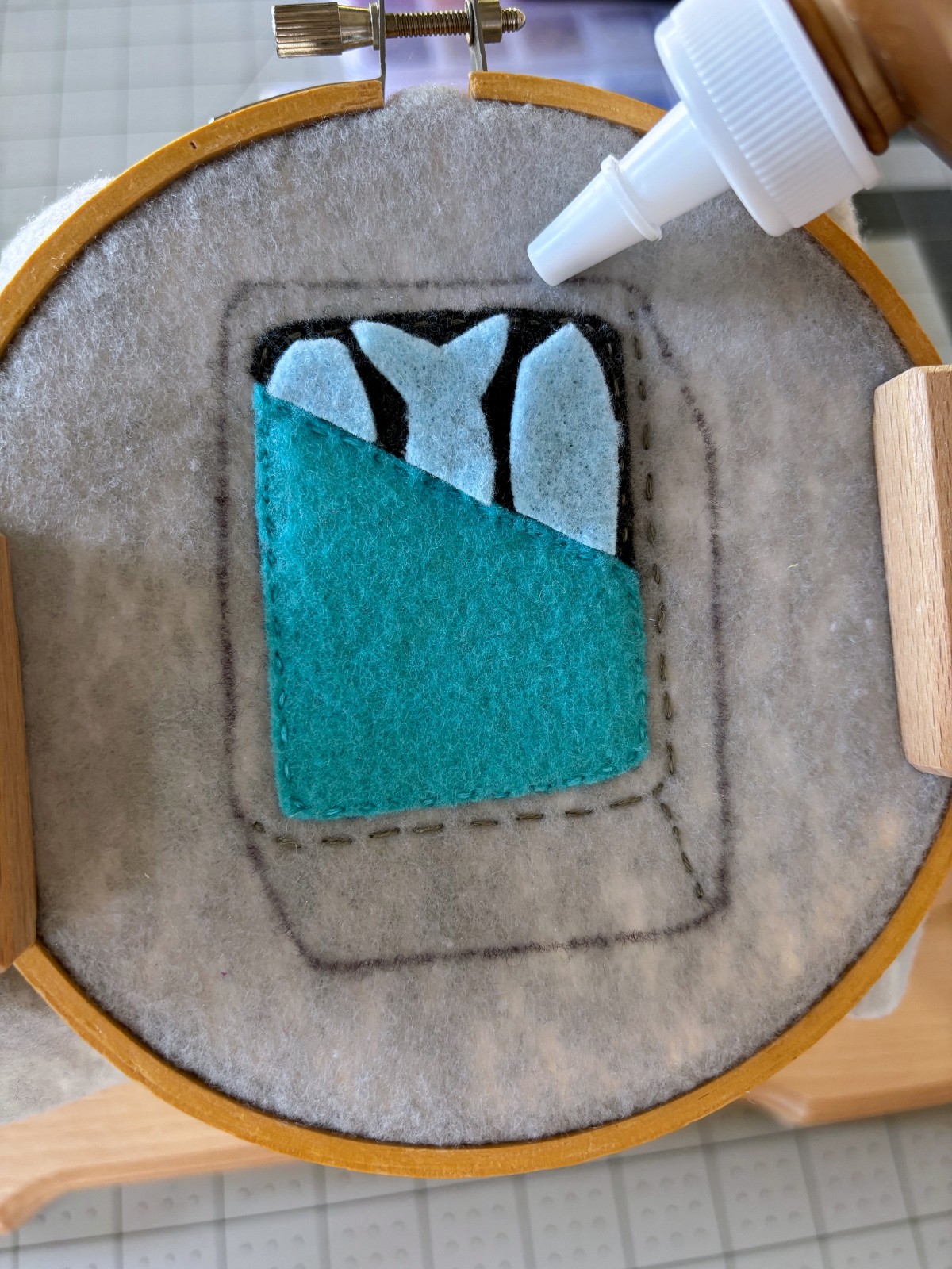 Glueing on the fish pattern pieces to the base with tacky glue.
