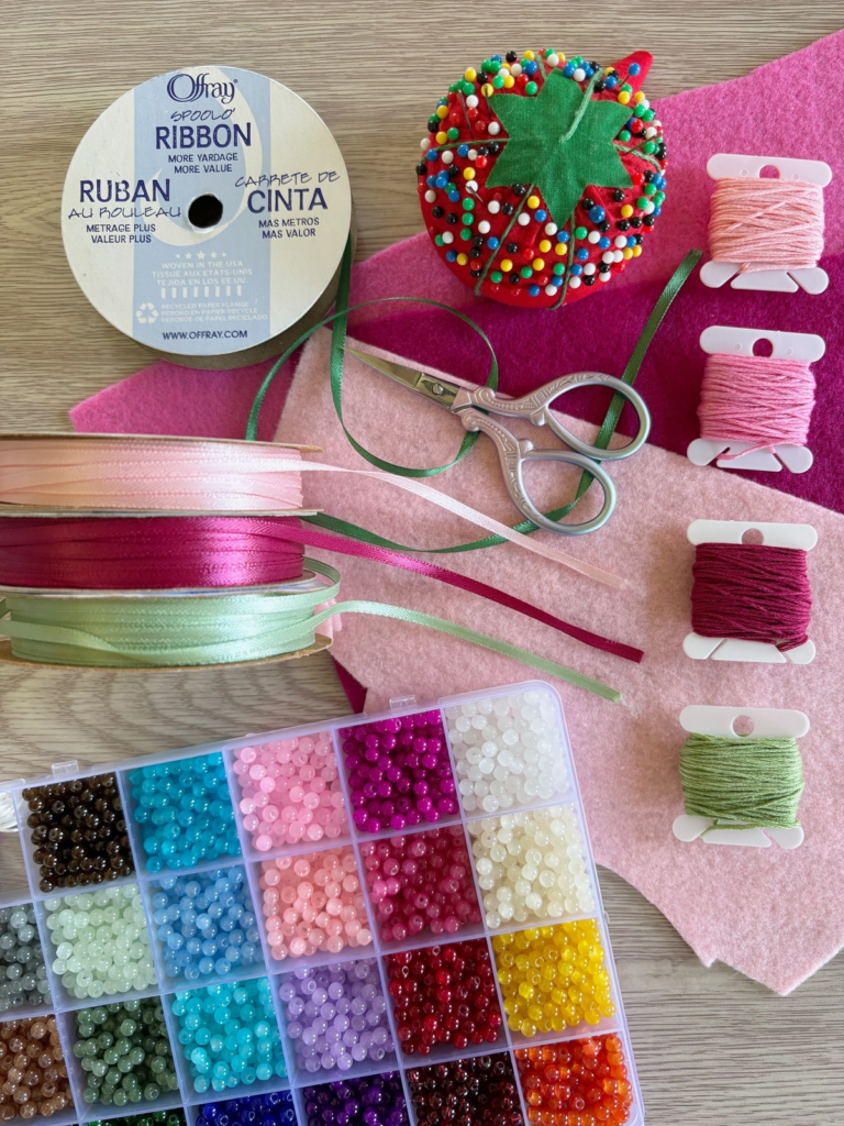 All the materials I used to make the flower crown including felt, sewing pins, ribbon, scissors, embroidery thread, and beads.