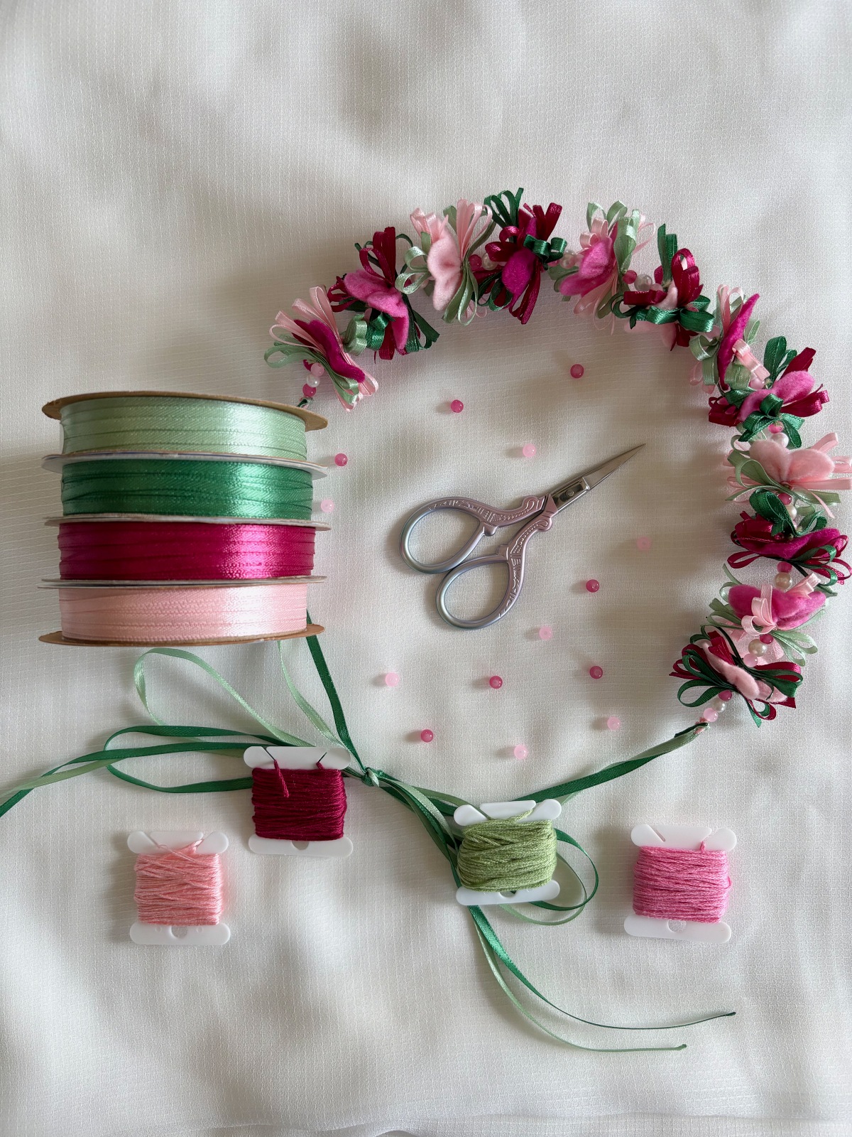Finished felt cherry blossom flower crown with ribbon, embroidery thread, beads, and scissors.