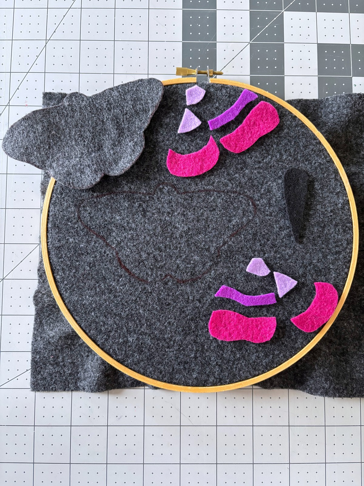 All felt pieces, one in an embroidery hoop and the rest cut out on a table.