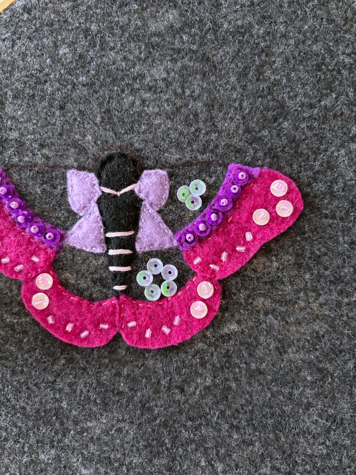 Light purple sequins placed on the moth wings. 