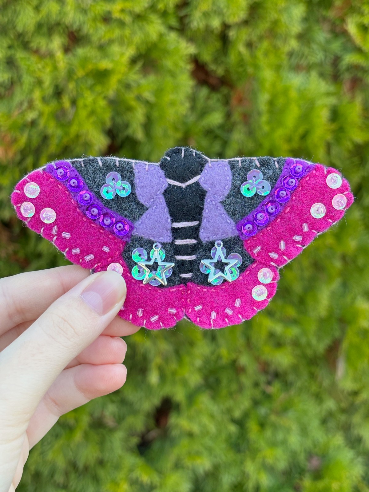 Fully finished moth ornament held outside.