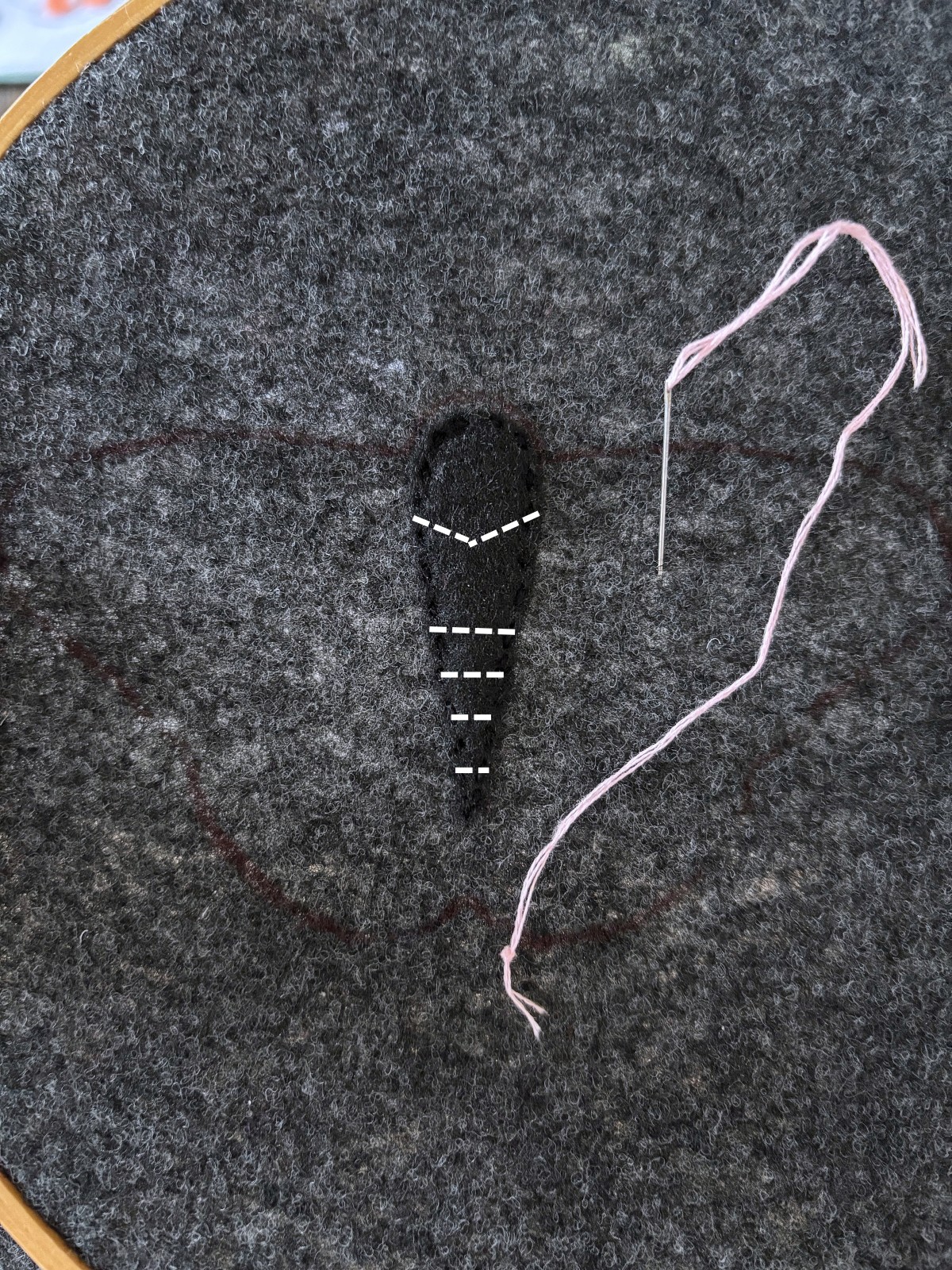 black moth felt body with embroidery details on the gray base piece.
