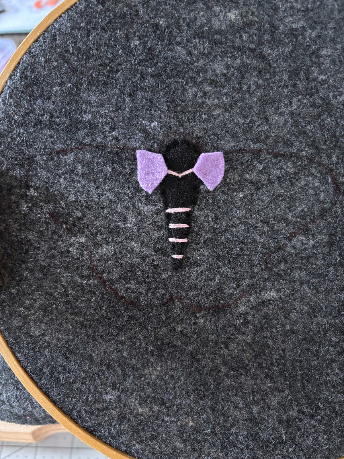Purple felt pieces placed on upper moth wings.
