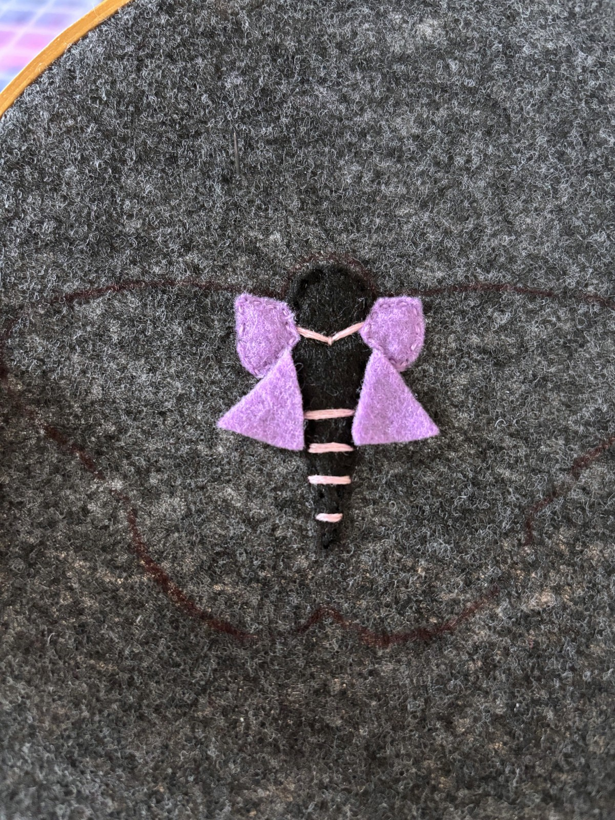 Purple felt pieces placed on lower moth wings.
