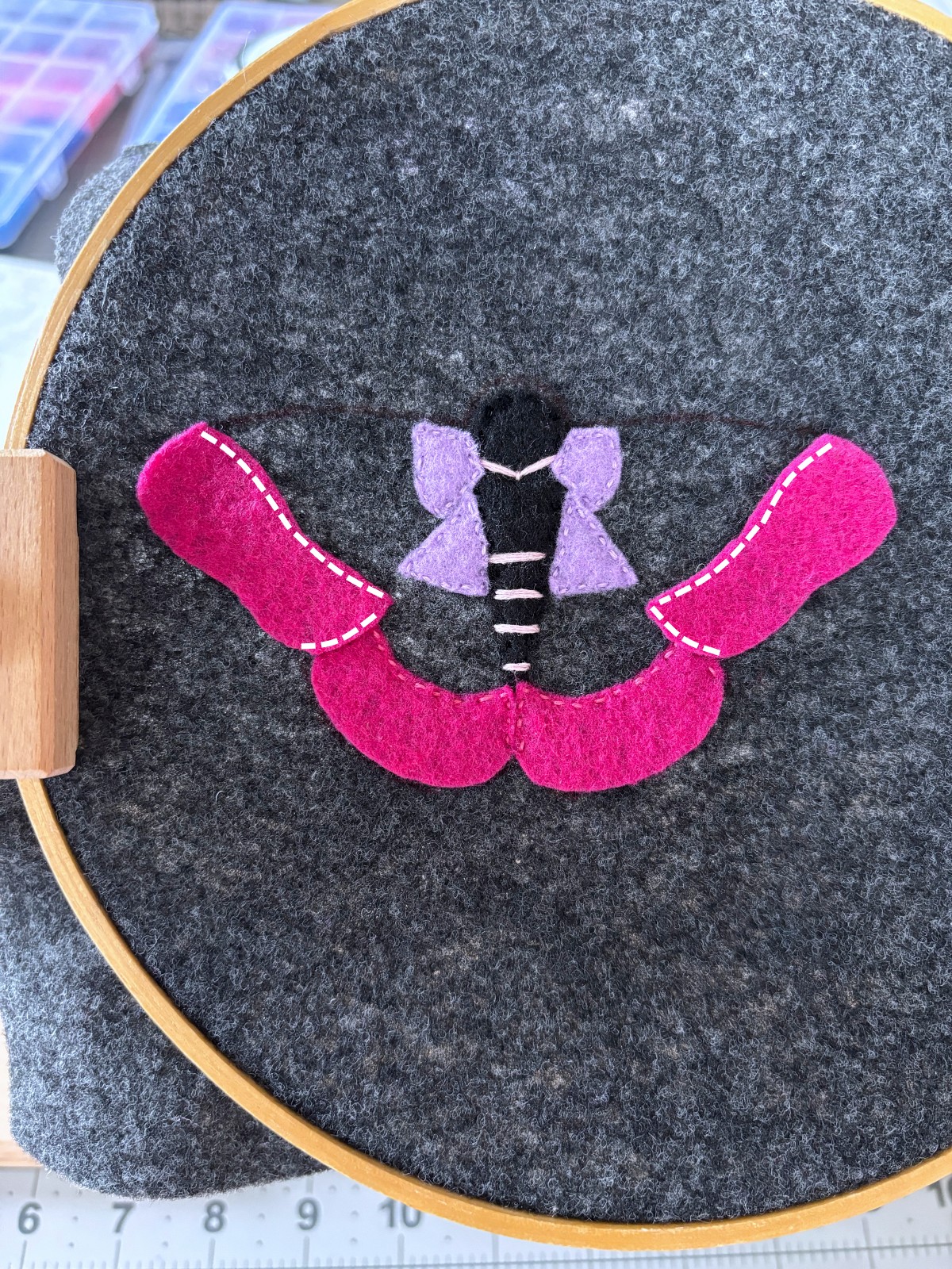 Dark pink upper moth wing felt pieces with instructional sewing lines to follow.