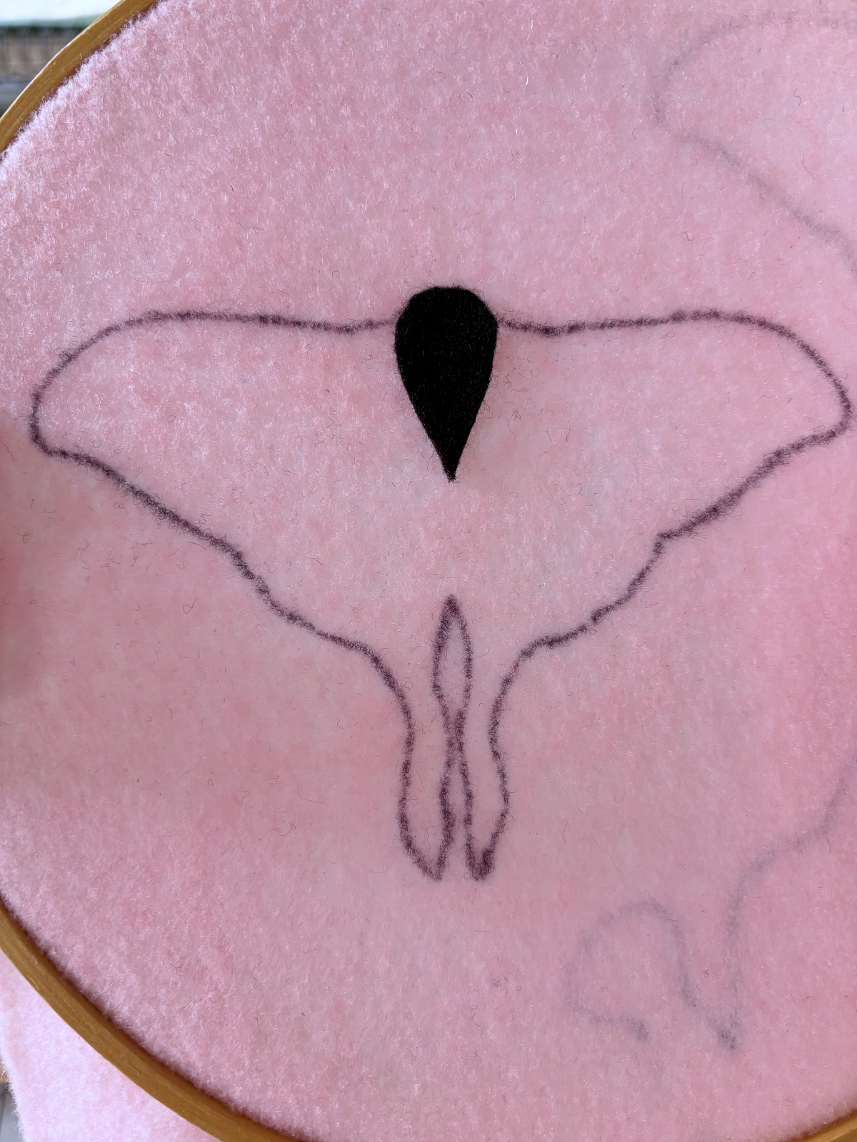 moth body piece placed on top of pink felt base.