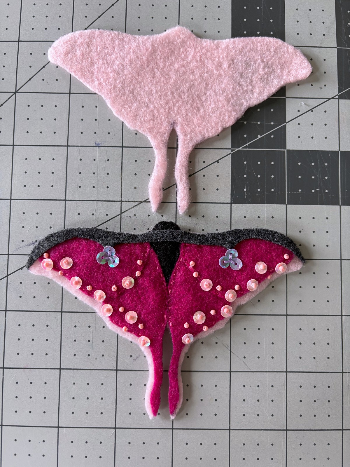 Both pink base pieces cut out on a table.